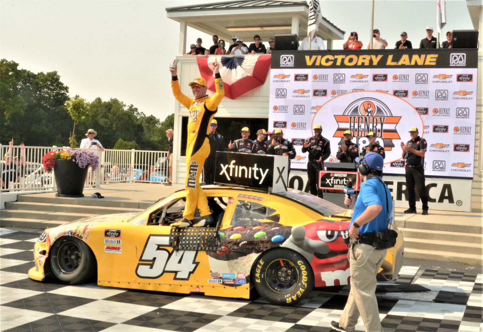 #54 Kyle Busch - - M&M Ice Cream (Toyota Supra) winner of 12th annual HENRY "180" Nascar Xfinity Series -Road America on 7/3/21. Kyle does a little celebrating on door of car. [Dave Jensen Photo]